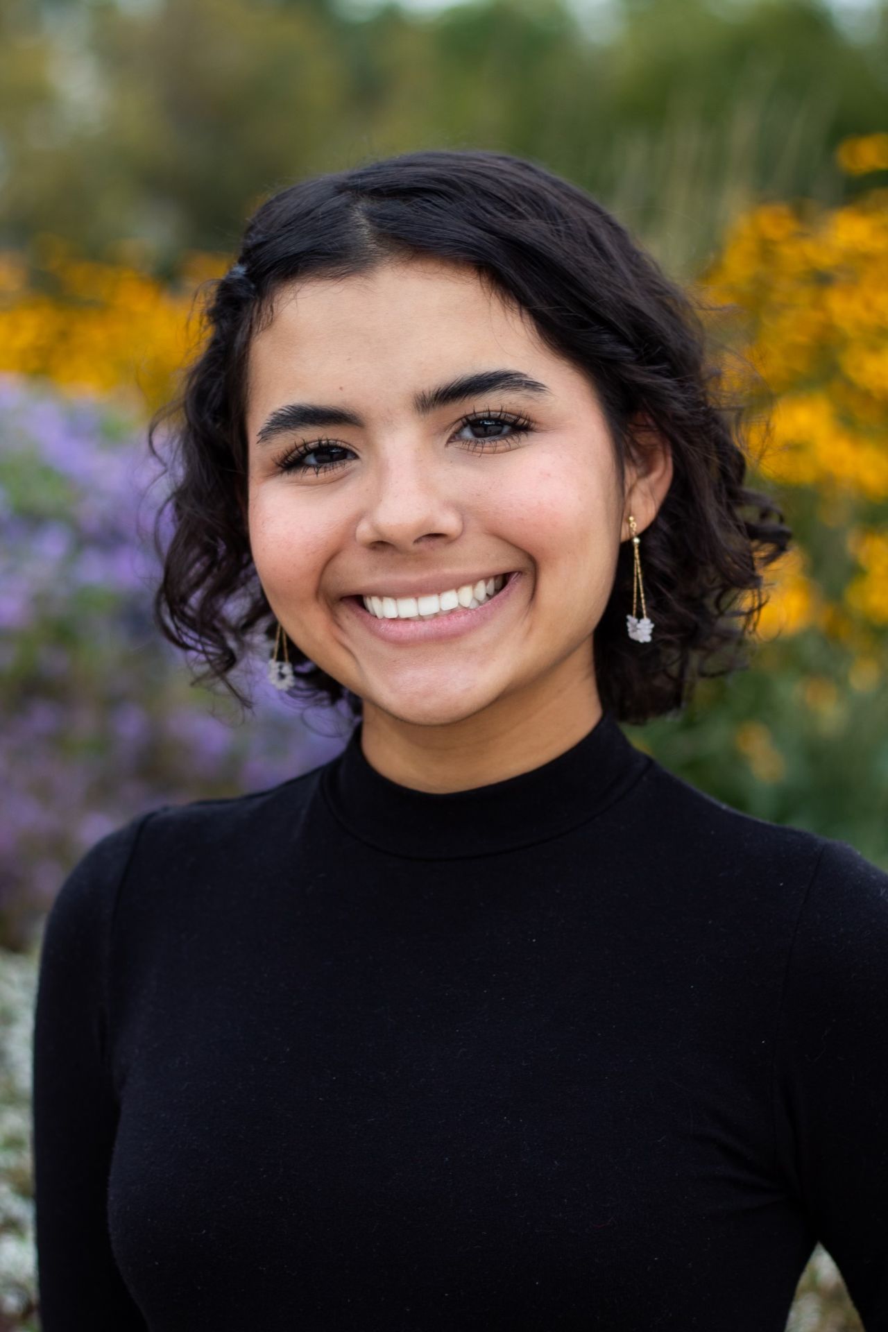 A young Latina woman smiles for the camera.