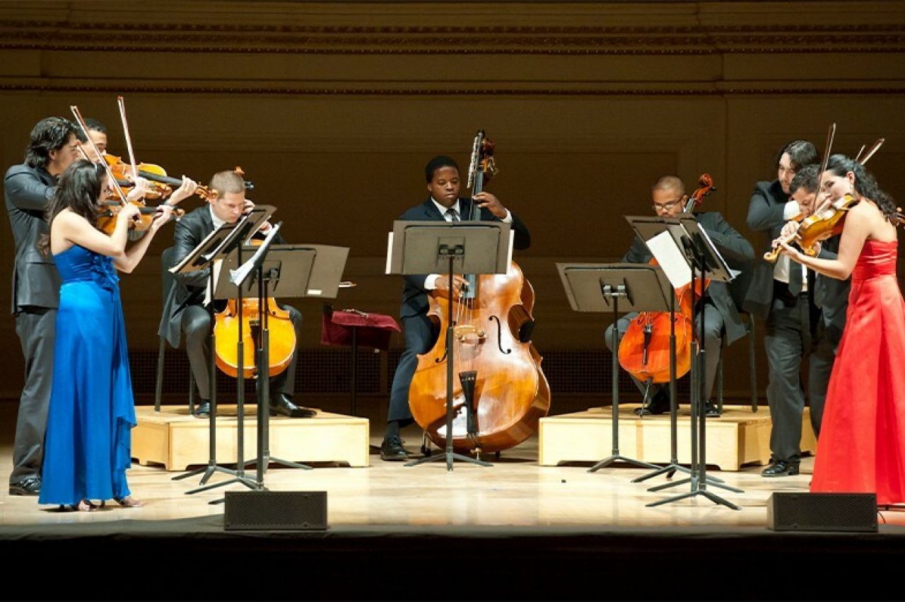 A diverse group of musicians perform on a stage.