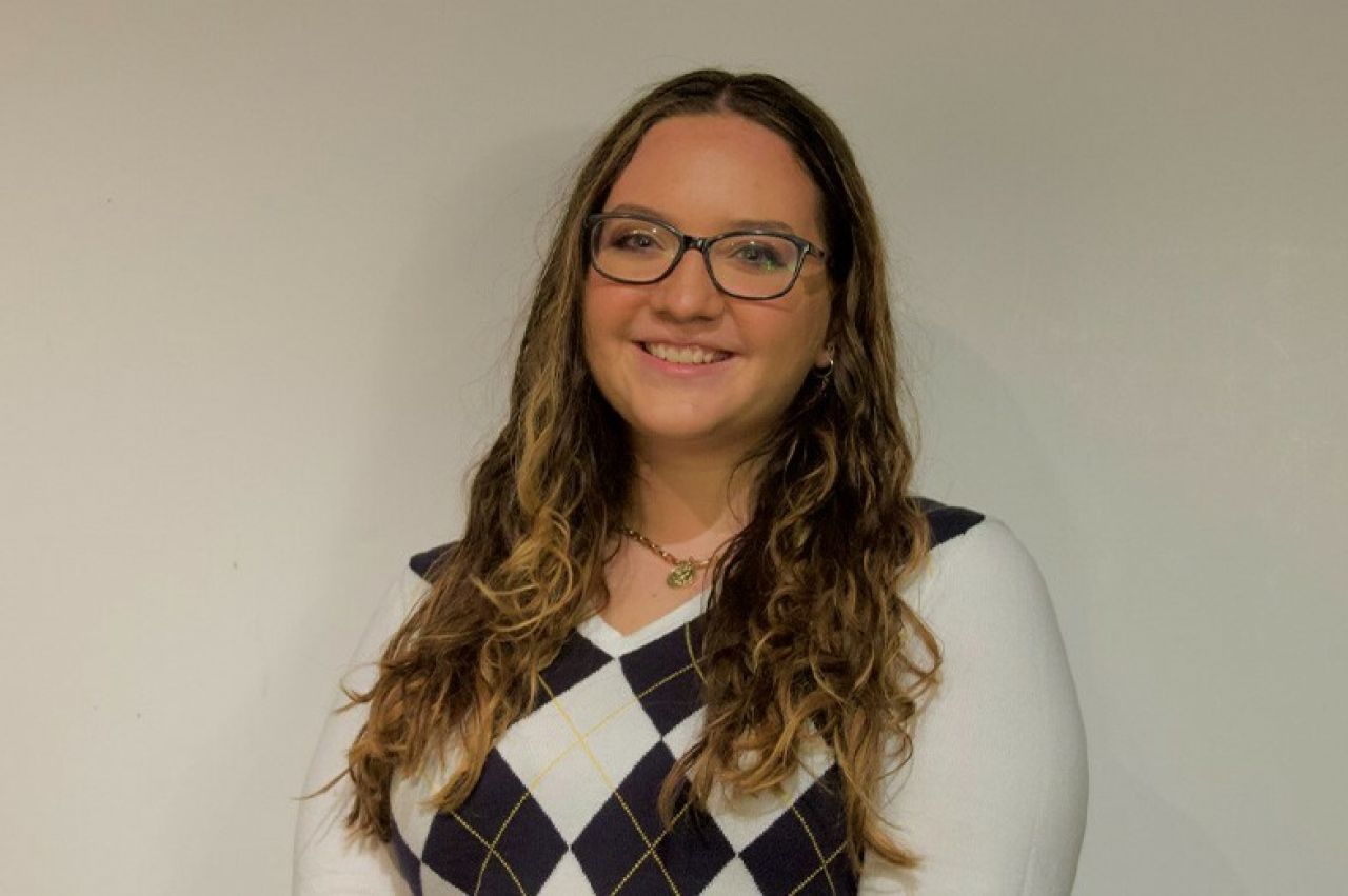 Head shot of a young white woman with long brown hair and glasses.