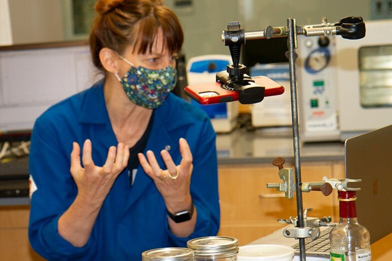 Woman in blue lab coat teaching