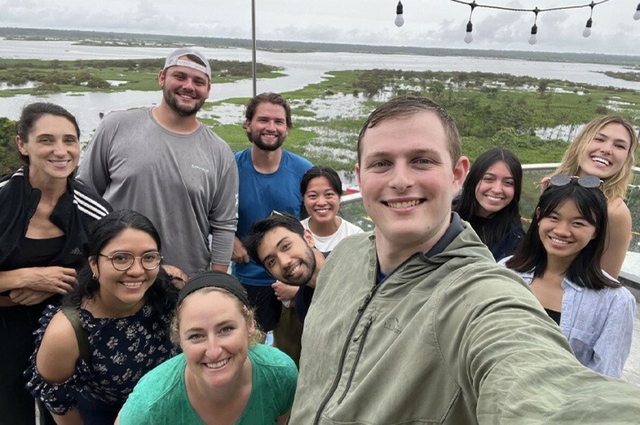 A male student is taking a selfie with his classmates and teacher during their time in Peru.