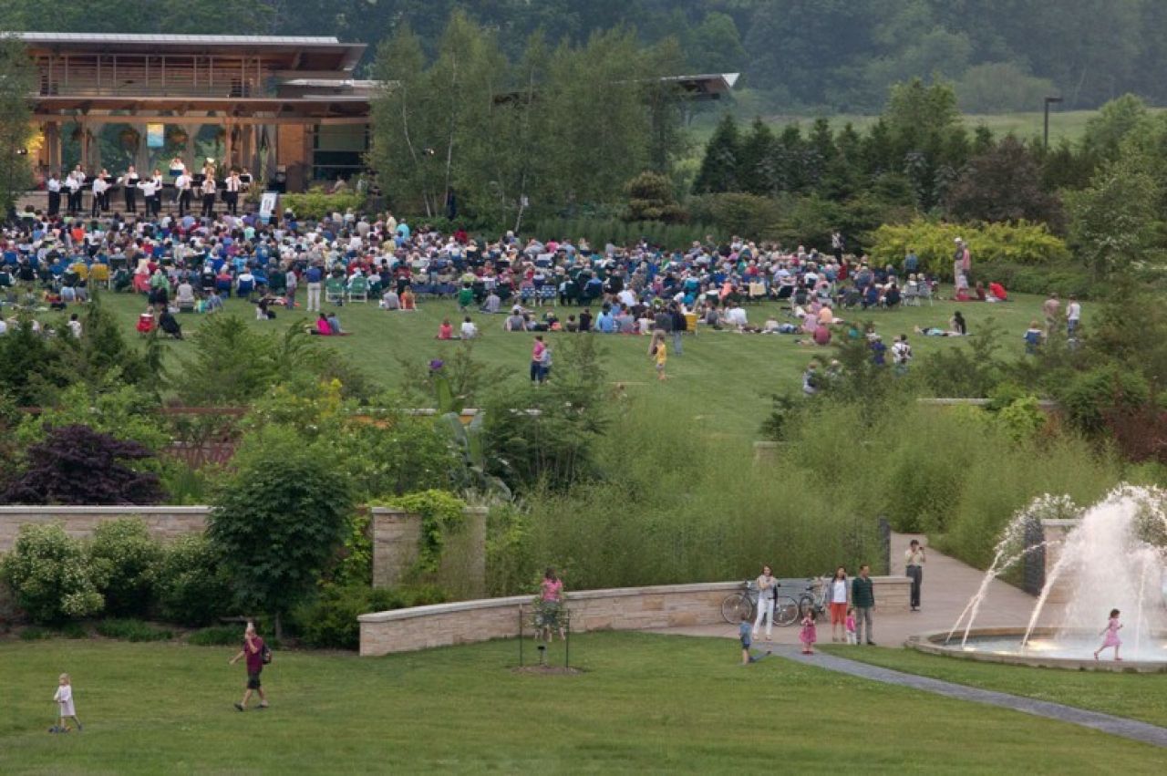 A large audience gatherin the field of the Penn State Arboretum for a Penn's Woods Music Festival live concert.