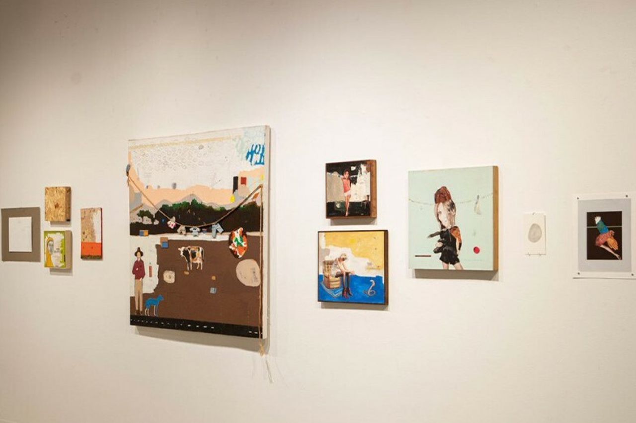 A horizontal line of differently sized, mixed media art works that are each colorful and abstract
