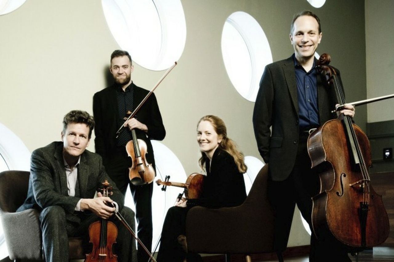 Group photo of the St. Lawrence String Quartet members posing with their instruments.