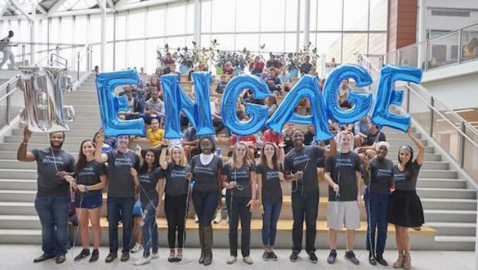 Students holding balloons that spell ENGAGE