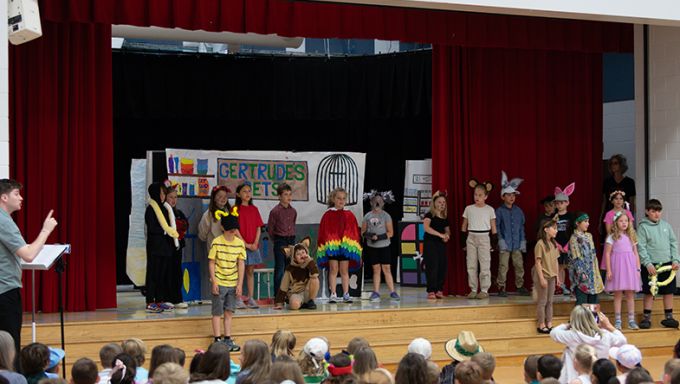 A stage with children performing a scene in an opera