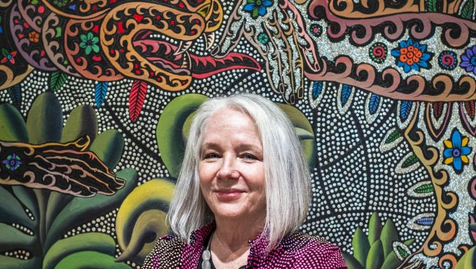 Woman with chin-length gray hair in front of multicolored wall