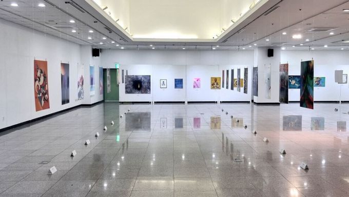 A white art gallery with colorful posters on the walls.