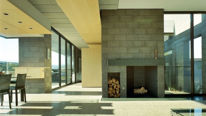 The inside of a house designed by Tod Williams featuring an open floorplan with floor to ceiling windows.
