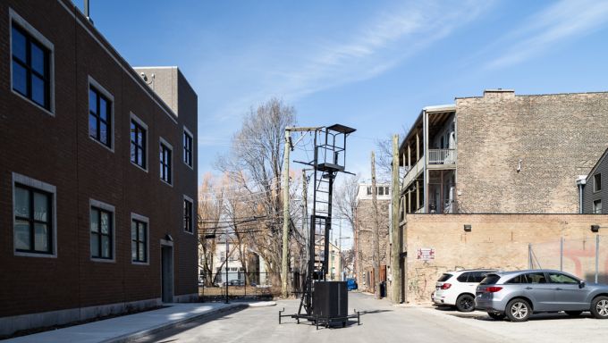 The Unmonument installation featuring a matte-black, steel industrial lift.