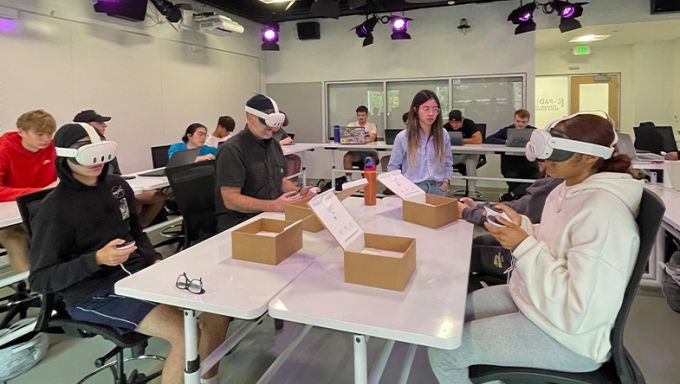 A group of students in a classroom wearing virtual reality headsets