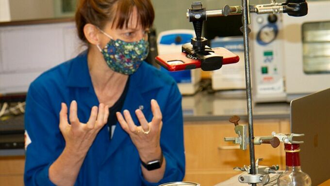 Woman in blue lab coat teaching