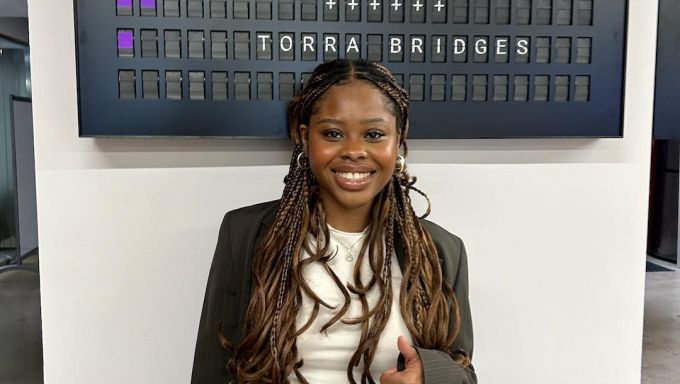 Young woman standing in front of BBC Studios sign