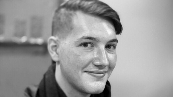 Black and white photo of a young man with shorthair smiling