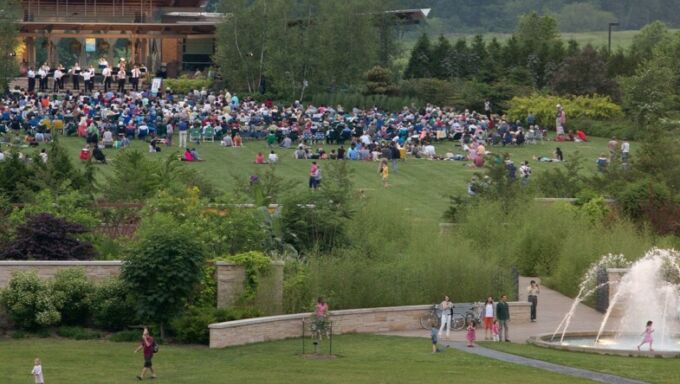 A large audience gatherin the field of the Penn State Arboretum for a Penn's Woods Music Festival live concert.
