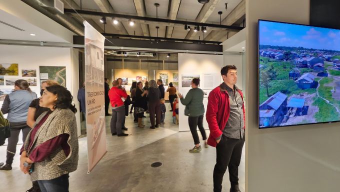 Viewers take in the “Tres Comunidades, Un Río” exhibit at the University of Washington.