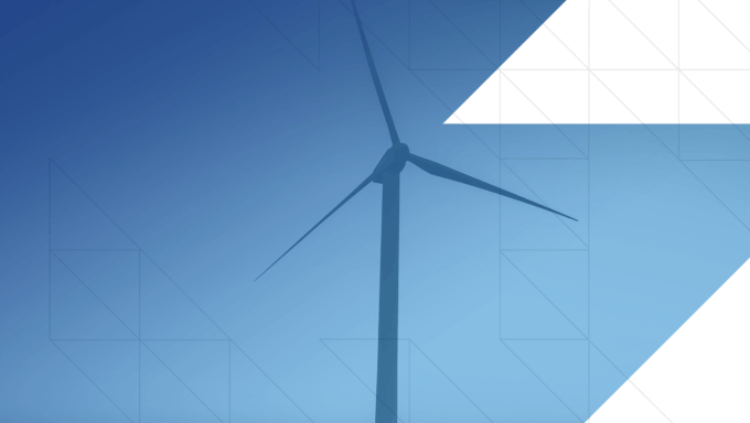 Far off shot of a wind turbine on a mountain tinted with a blue ombre overlay.