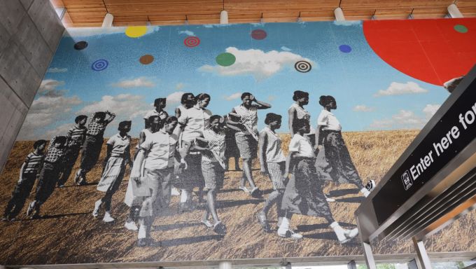 Mural showing young people of color walking across a Midwestern prairie