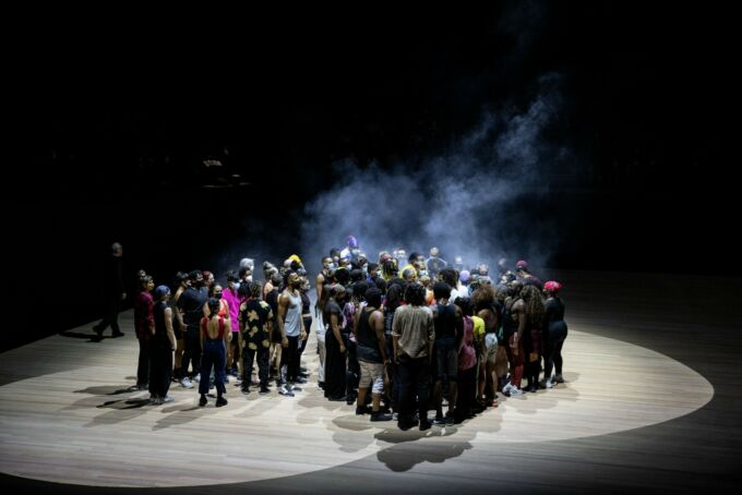 Dancers of the 'What Problem?' production huddled under spotlights on stage.