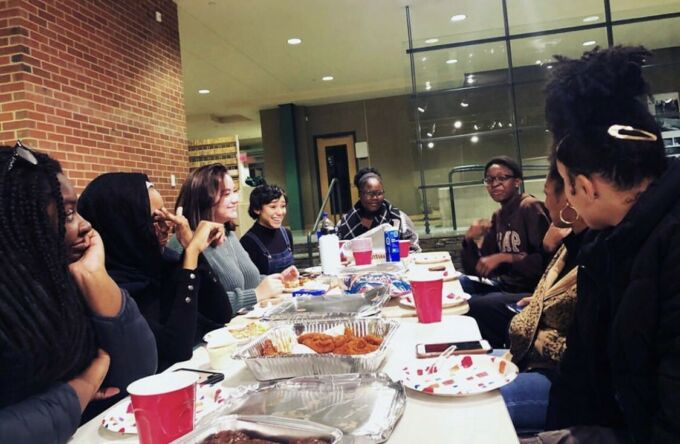Students gathered around a table eating and talking.