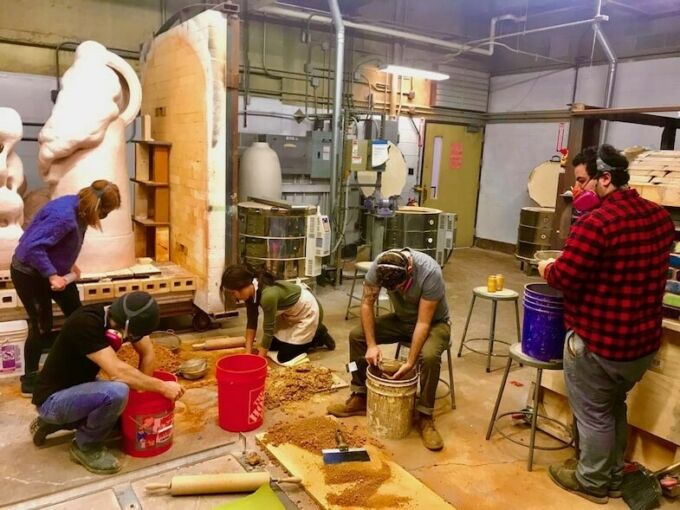 Ceramics students process red clay in the studio