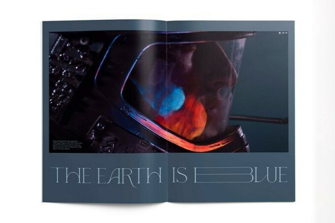 A magazine spread of a man's face in a space suit with the words The Earth is Blue.