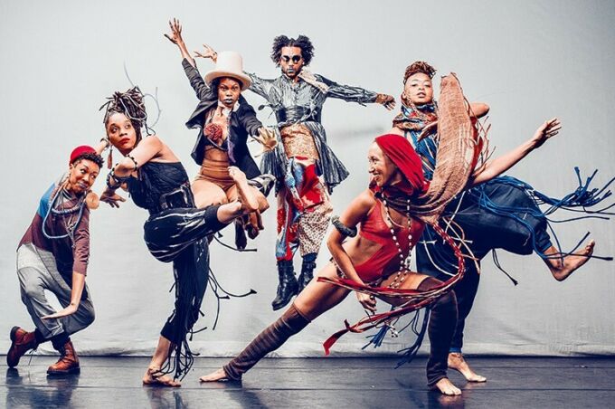 A group of dancers stand in exaggerated poses.