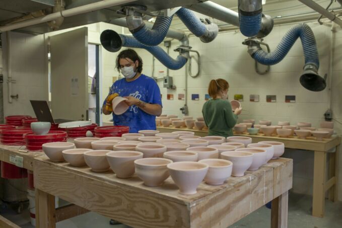 Table full of ceramic bowls waiting to be fired