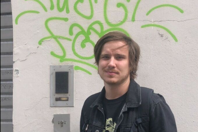 Bryce Brucker in front of a graffitied wall in Berlin.