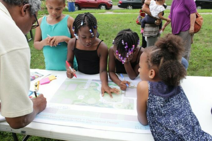 A man in the foreground writing on a landscape plan with children surrounding him.