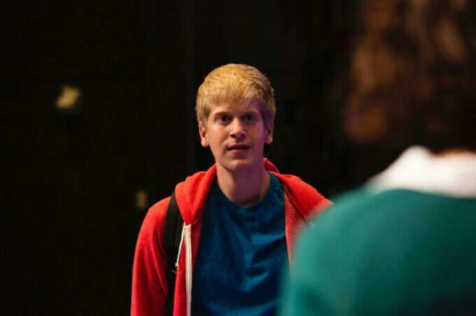 A white young man with a red hooded sweatshirt