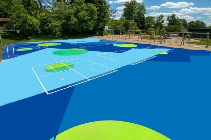 Vibrant green and blue geometric shapes painted on a basketball court.