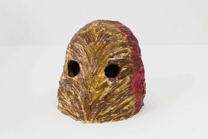 brown and ornage clay sculpture that looks similar to a small head of an owl