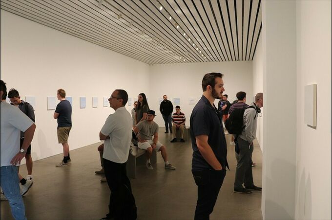 Students and faculty looking at pieces of art on the walls of a gallery in moCa Cleveland.
