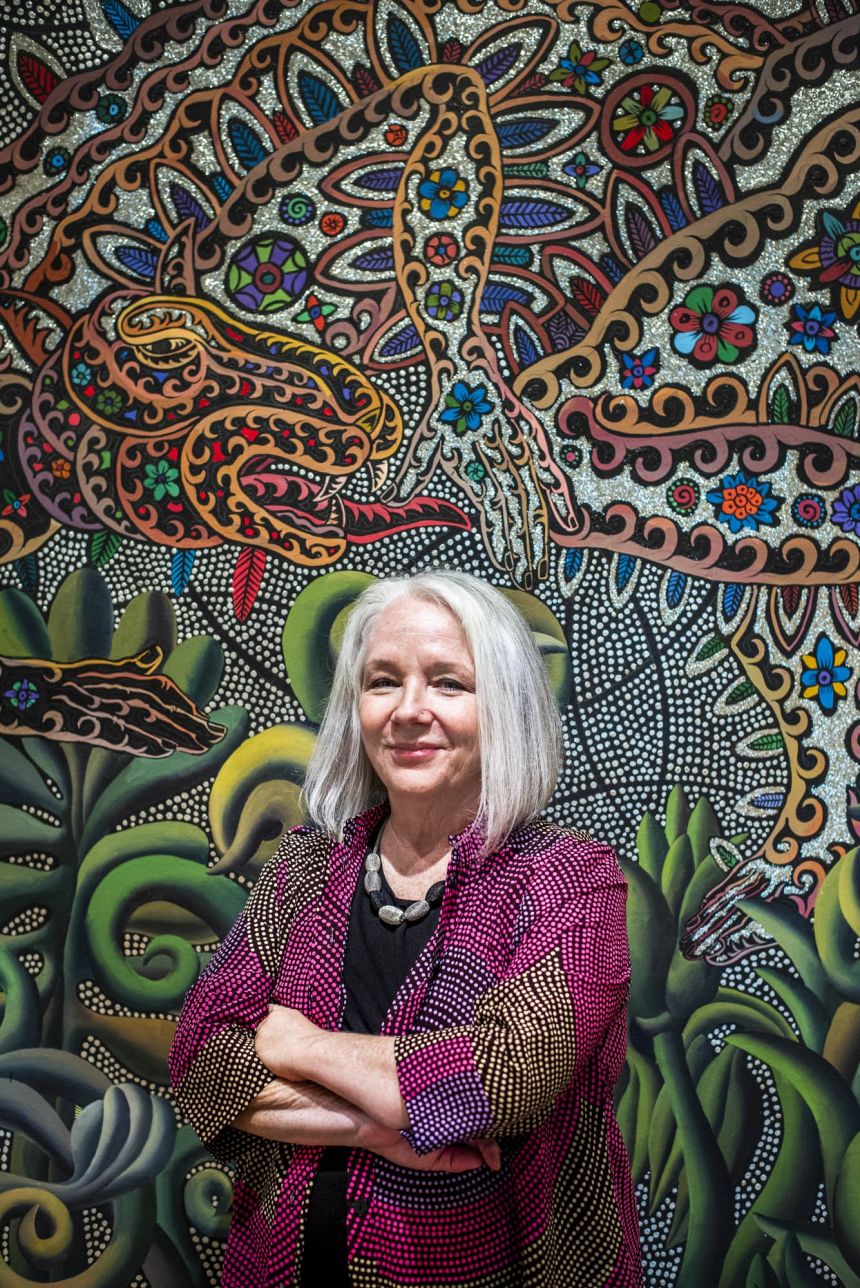 Woman with chin-length gray hair in front of multicolored wall