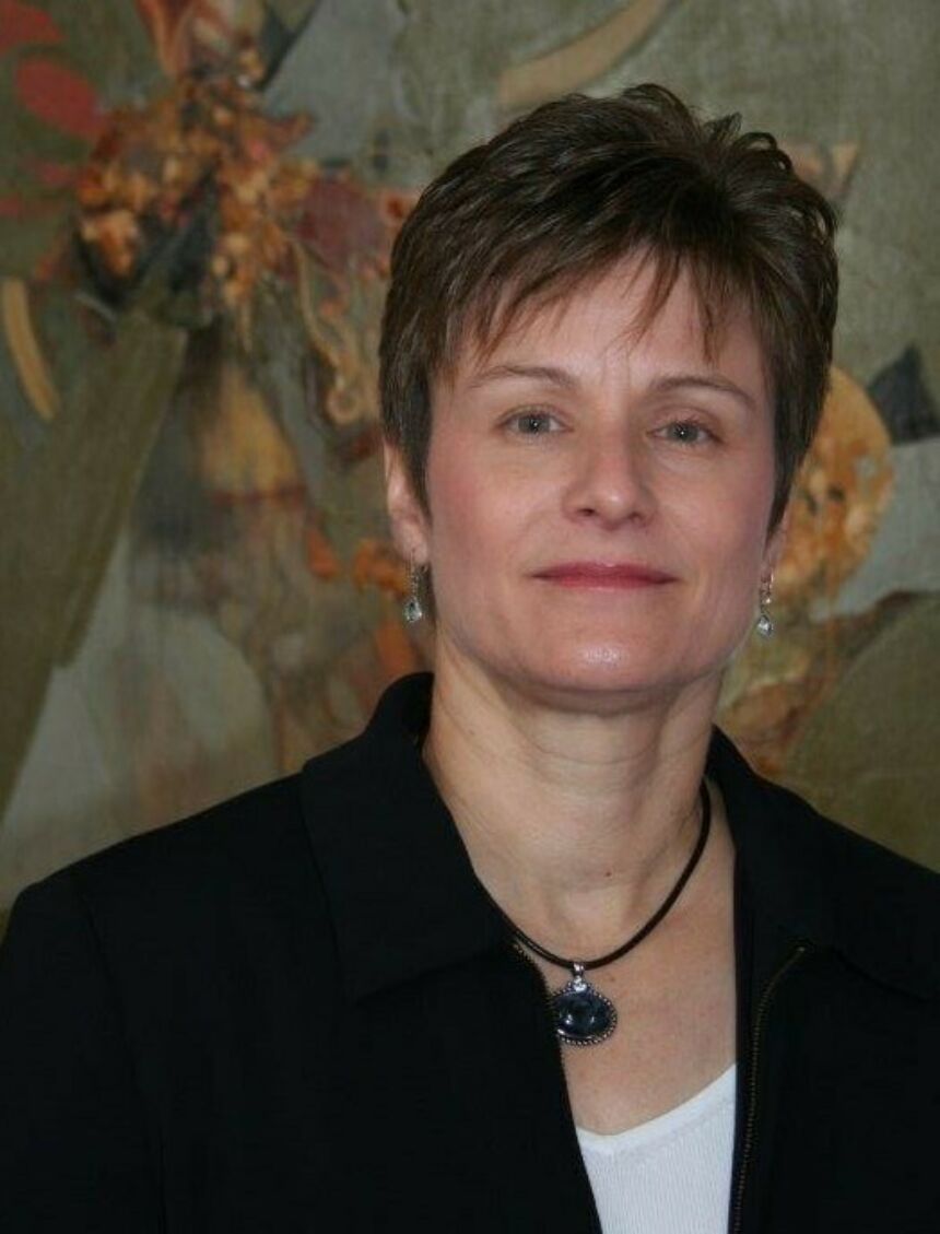 A woman with short hair looks at the camera.