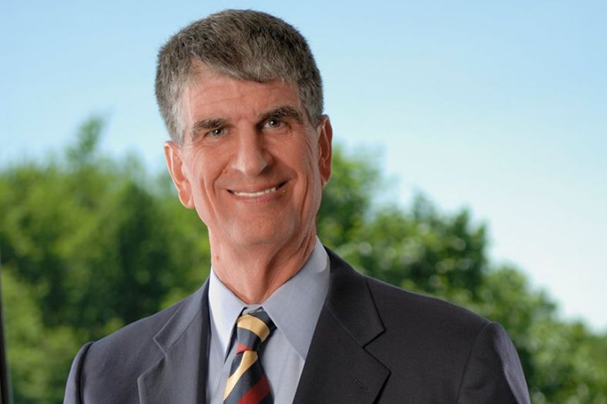 Head shot of an older white man with a grey hair smiling