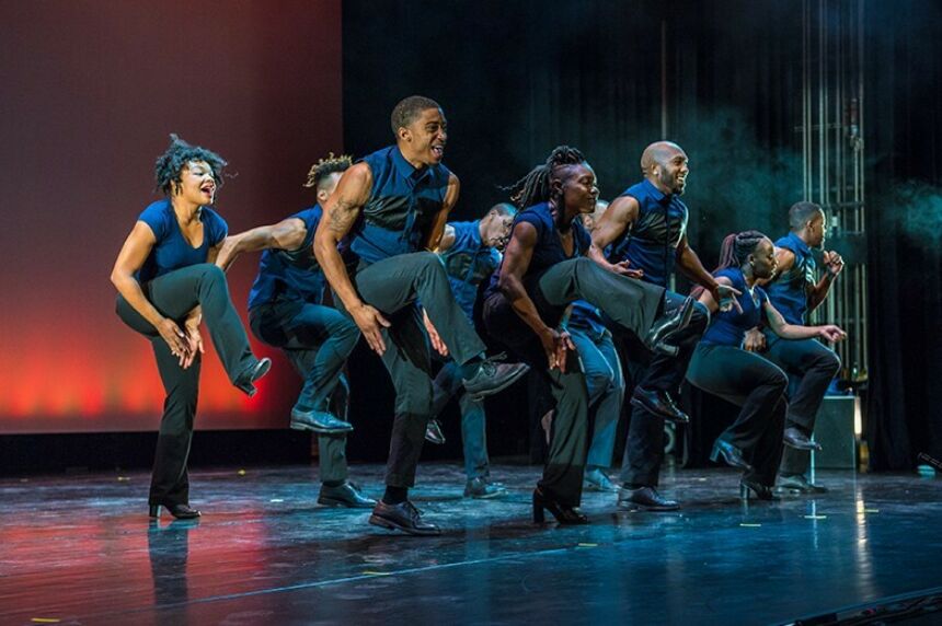 A group of dancers step high on stage.