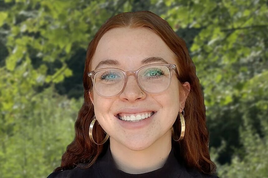 Girl with red hair and glasses smiling