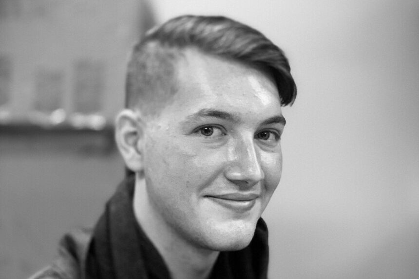 Black and white photo of a young man with shorthair smiling