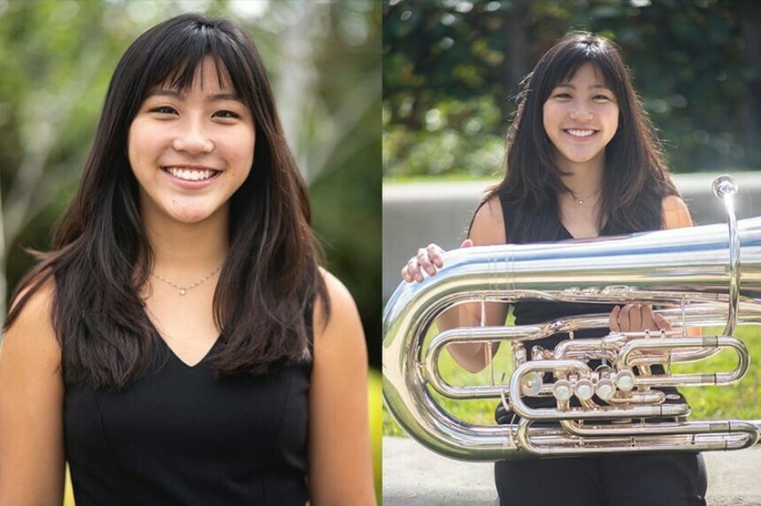 Dark haired Asian woman smiling outside holding a tuba