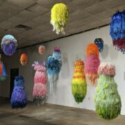 A group of colorful art installations suspended from the ceiling.