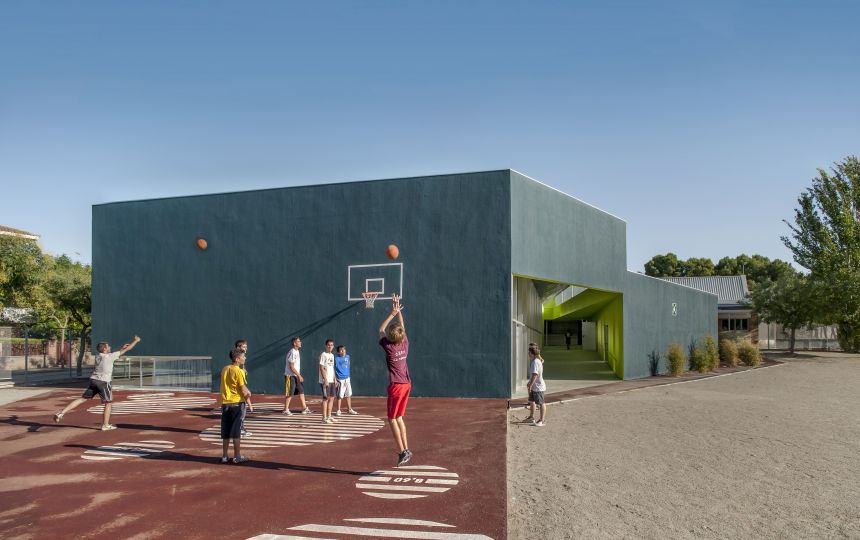 An architectural rendering of a high school with students shooting basketball on the adjoining playground court.