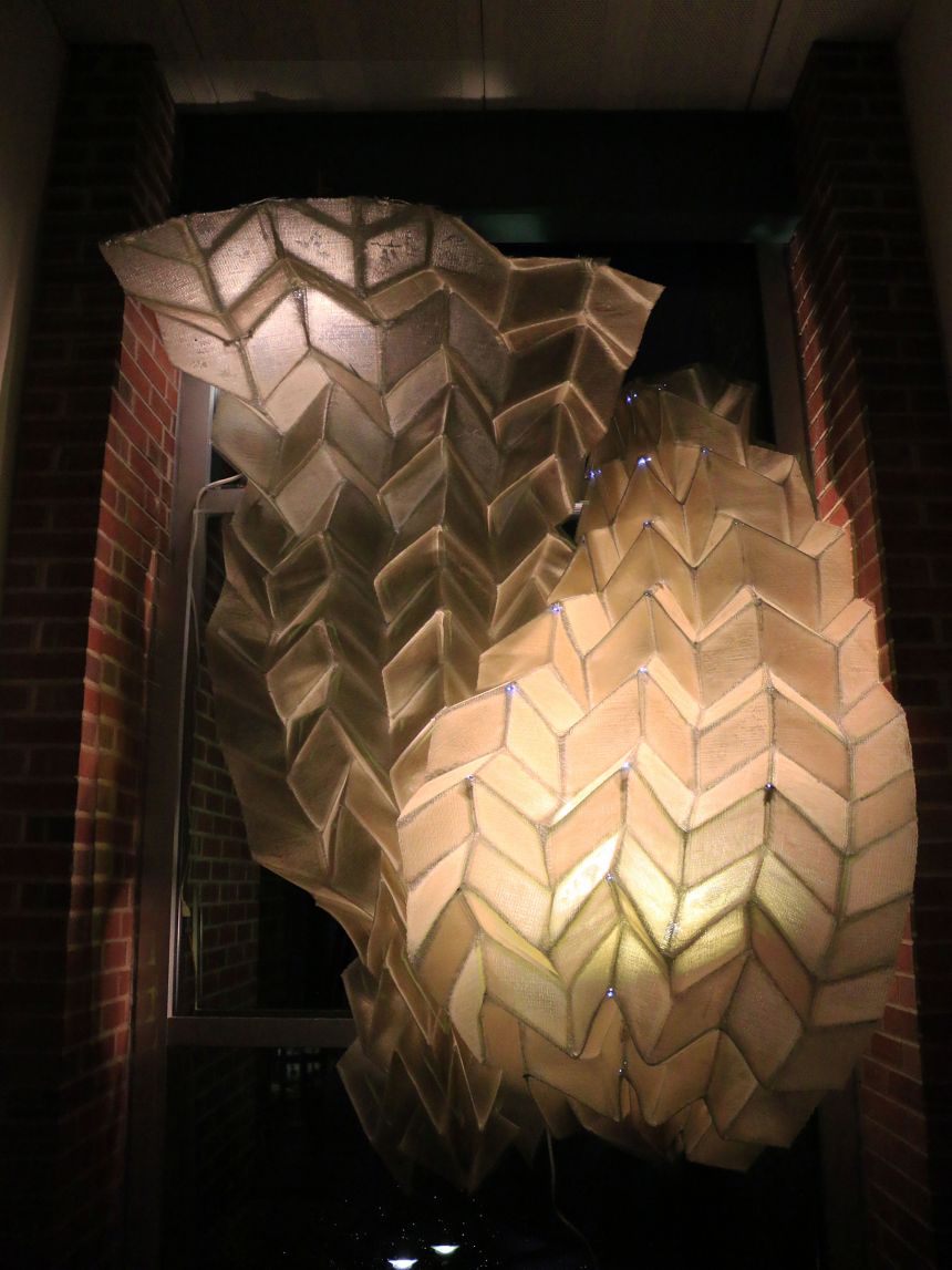 Two large-scale origami structures are illuminated from within.