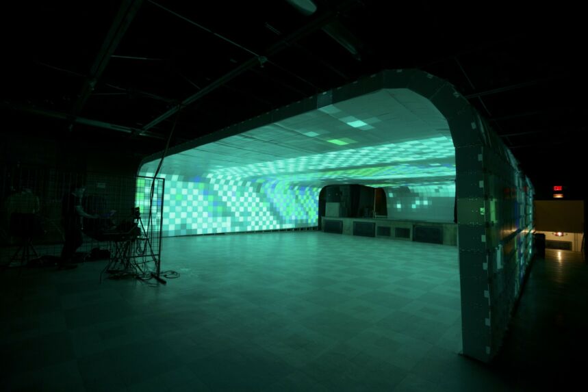 Interior shot of extra wide archway comprised of teal, green, and blue light boxes.