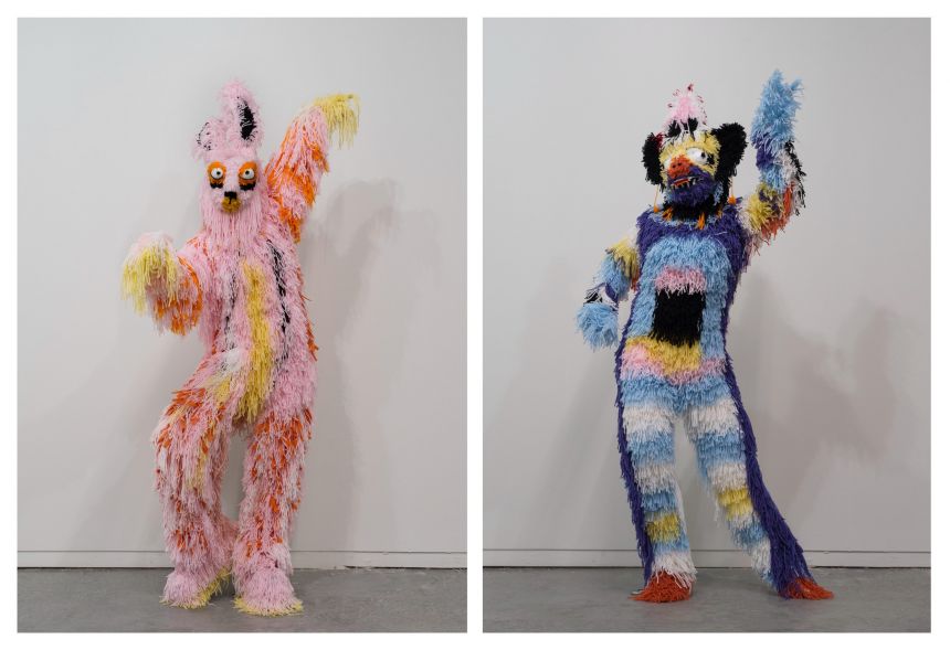 Two brightly colored, feathery costumes in dancing poses.