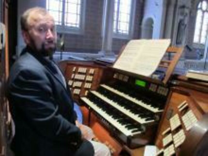 Photo of Vincent Benitez sitting at the Grand-Orgue in Église de la Sainte-Trinité (Roman Catholic church).