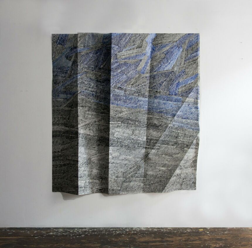 Photo of a large scale black and blue painting on folded paper hanging in an art gallery.