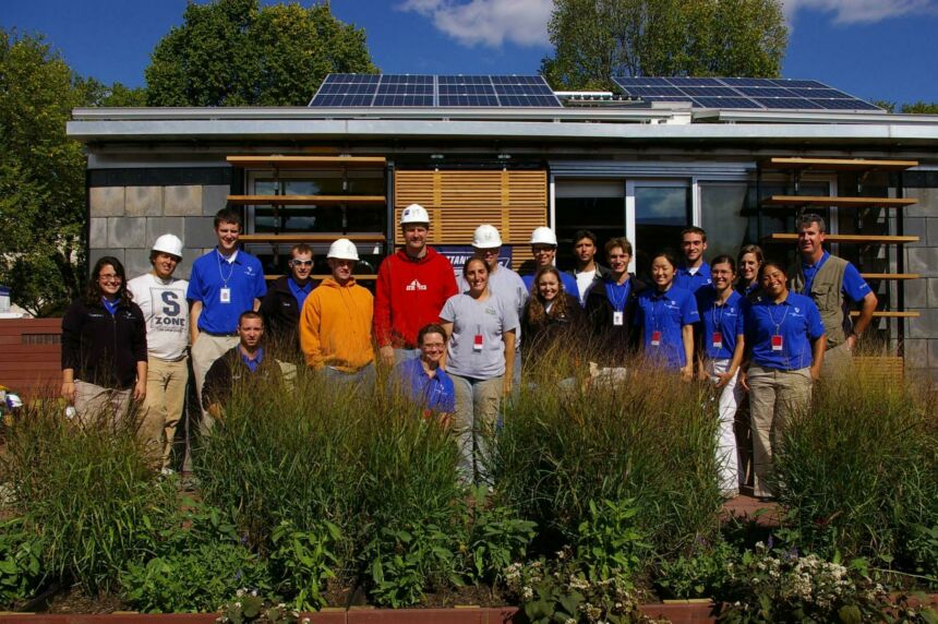 Group photo of Morning Star Solar Decathlon Team standing in front of a newly constructed modern house with solar paneling.