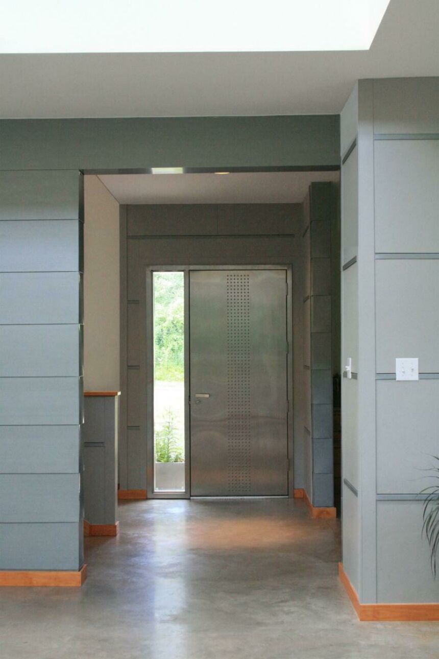 Interior photo of the house's grey-painted foyer and stainless steel front door.